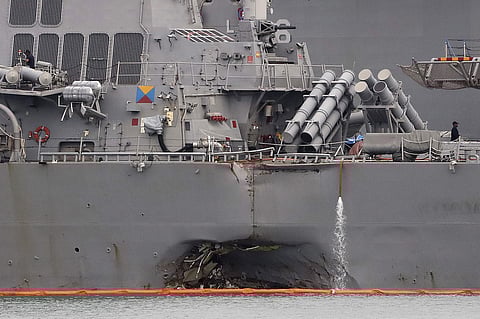 The damaged port aft hull of the USS John S. McCain, is visible while docked at Singapore's Changi naval base on Tuesday, Aug. 22, 2017 in Singapore. | AP
