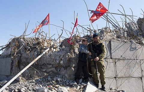 A young boy poses for a picture with a pro-Russian separatist soldier at the top of the Savur Mohyla memorial in Snizhne, eastern Ukraine on Sept. 26, 2014. (File | AFP)