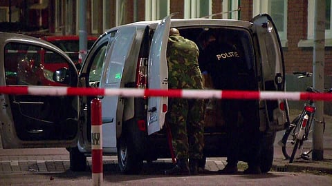 In this image taken from video police officers examine a van behind a cordoned-off area in Rotterdam (AP)