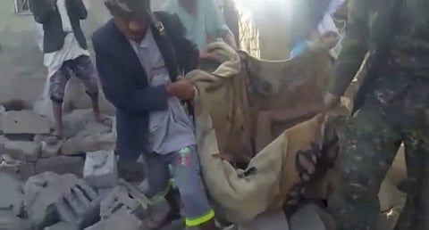 A victim is carried from the site of an airstrike on a hotel in Arhab, Yemen (AP)