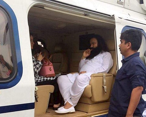 Dera Sacha Sauda chief Gurmeet Ram Rahim in a helicopter in which he was flown from Panchkula to Rohtak town to lodged in jail on Friday. (PTI)