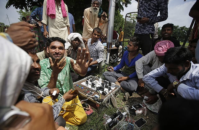 Dera Sacha Sauda followers charging their phones as they wait for the verdict. Mobile internet and data services have been suspended for 72 hours in Punjab, Haryana and Chandigarh. (Photo | AP)