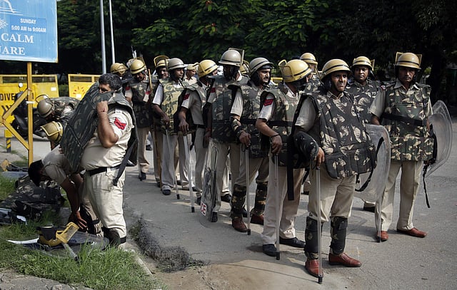 A policeman seen putting on a bullet proof vest as he joined others on a road leading to the court in Panchkula ahead of the verdict being pronounced. (Photo | AP)