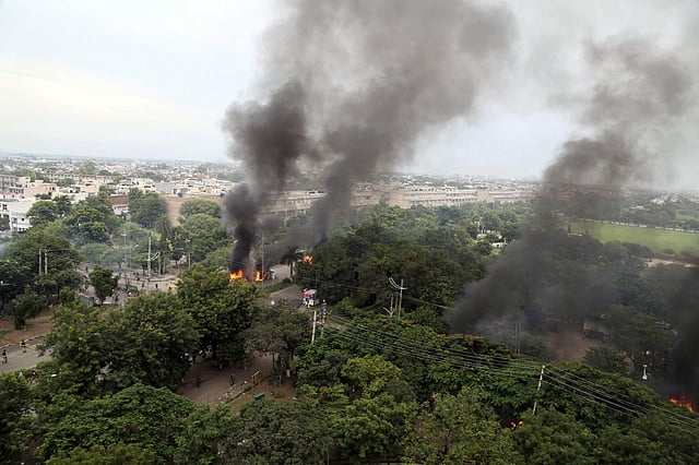 Smoke billows after supporters of the Dera Sacha Sauda sect set vehicles on fire in Panchkula. (Photo | AP)