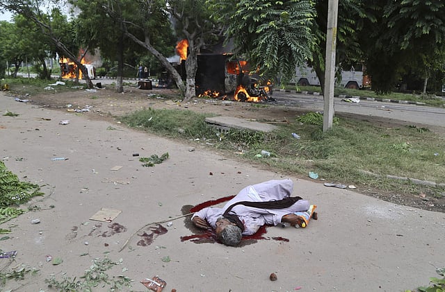 A man, presumably dead, lies on a road in a pool of blood after Dera Sacha Sauda sect members went on a rampage in Panchkula.  (Photo | AP)