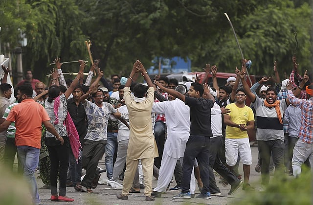 Supporters, with their back towards the camera, try to calm other supporters of the Dera Sacha Sauda sect near the court in Panchkula after the verdict. (Photo | AP)