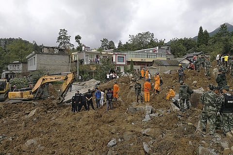 Rescuers search for survivors at a buried houses following a landslide in Nayong county in southwest China's Guizhou province, Monday, Aug. 28, 2017. The landslide buried dozens of homes in southern China, killed several and leaving dozens missing, the lo