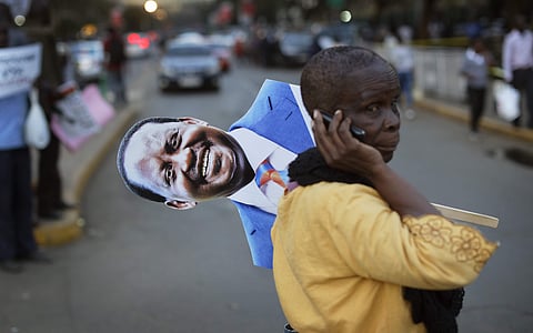A supporter of main opposition leader Raila Odinga holds a placard of his face as she attends a small demonstration outside the Supreme Court in downtown Nairobi, Kenya Friday, Aug. 18, 2017.  | AP