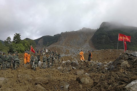 Rescuers search for survivors following a landslide in Nayong county in southwest China's Guizhou province, Monday, Aug. 28, 2017. The landslide buried dozens of homes in southern China, killed several and leaving dozens missing, the local government said