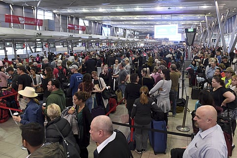 People crowd a terminal at Sydney's domestic airport as passengers are subjected to increased security, in Sydney, Australia (AP)