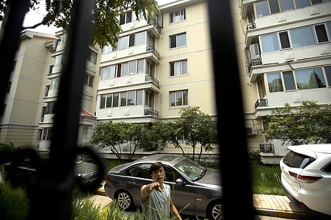 Chinese security guard attempts to stop a photographer from taking photos of an apartment building where Liu Xia, the wife of late Nobel Prize winner Liu Xiaobo, has been living under house arrest in Beijing. (AP)