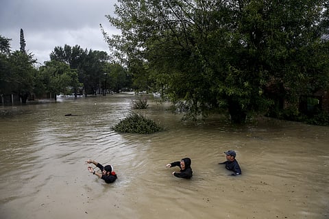 People wade through chest deep water down Pine Cliff Drive as Addicks Reservoir nears capacity due to near constant rain from Tropical Storm Harvey, Tuesday, Aug. 29, 2017 in Houston. | AP