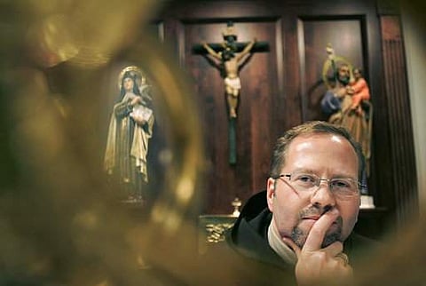 Dennis-Anthony Wyrzykowski of Carmel Laboratories LLC, poses in front of an alter in a chapel at a Carmelite monastery, in Millbury, Mass.