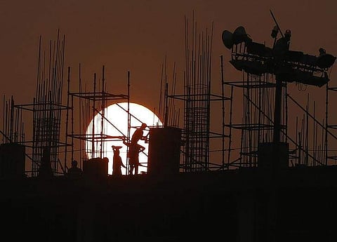 Labourers work at the site of a government hospital building under construction in New Delhi. (Photo | Reuters)
