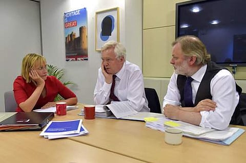 British Secretary of State for Exiting the European Union David Davis, center, speaks with Director General at the Department for Exiting the European Union Sarah Healey, left, and UK's Permanent Representative to the European Union Tim Barrow, right, dur