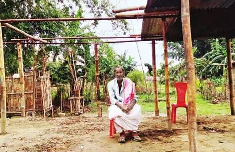 Sibaram Das sits in what was once his house but has now been washed away by the flood, in Amtola Milanpur, North Lakhimpur district. (Express)