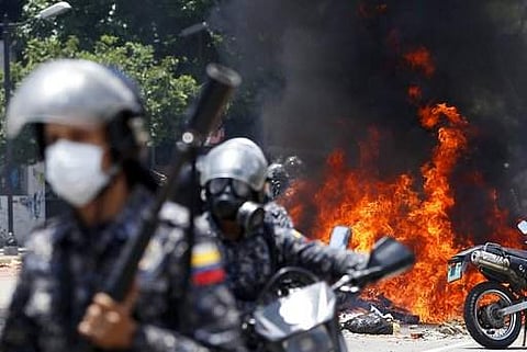 Bolivarian National Guards move away from the flames after an explosion in Altamira Plaza during clashes with anti-government demonstrators in Caracas, Venezuela on July 30. (File Photo | AP)