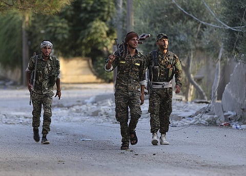 In this Saturday, June 22, 2017 photo, U.S.-backed Syrian Democratic Forces (SDF) fighters, prepare to move for a battle against the Islamic state militants, in Raqqa, northeast Syria. Several weeks ago, the SDF — which is dominated by Syrian Kurdish forc