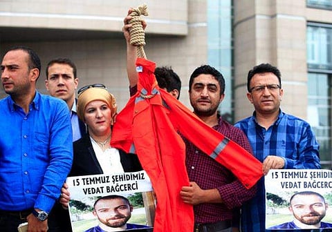 In this representational image, members of the family of a victim killed during the July 16, 2017 failed coup attempt, one holding a noose and a Guantanamo Bay prison-style uniform, hold a protest outside Istanbul's court demanding the execution of coup p