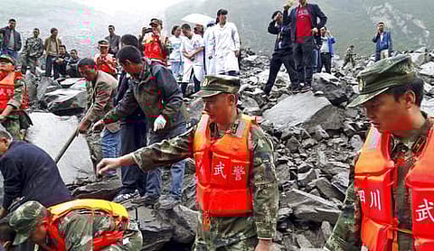 Emergency personnel and local people work at the site of a landslide in southwestern China. (File photo | AP)