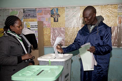 A Kenyan casts his vote watched by a polling official at a polling station in Nairobi, Kenya, Tuesday, Aug. 8, 2017. Kenyans are going to the polls to vote in a general election after a tightly fought presidential race between incumbent President Uhuru Ke