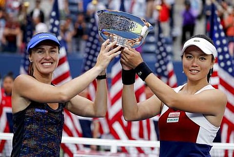 Martina Hingis, of Switzerland, left, and Chan Yung-Jan, of Taiwan, hold up the US Open women's doubles championship trophy. | AP