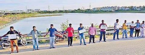 Residents and activists forming a human chain at Porur demanding removal of encroachments in Porur lake on Sunday | Sunish P Surendran