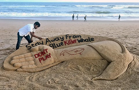 Sand artist Sudarsan Patnaik creates a sculpture to create awareness on Blue Whale game on Puri beach on Monday | Express