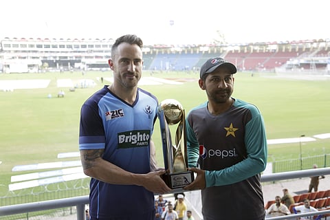 Skipper World XI Faf du Plessis, left, holds the World XI trophy with his Pakistani counterpart Sarfraz Ahmed ahead of the World XI series, at Gaddafi stadium in Lahore. | AP