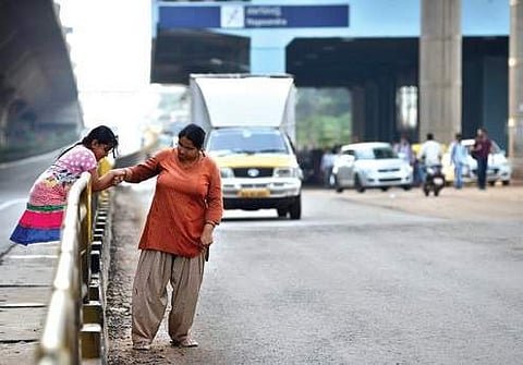 A young girl precariously tries to cross the busy highway to reach Nagawara Metro station in Bengaluru | pushkar v