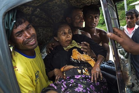 FILE - In this Sept. 4, 2017, file photo, an injured elderly woman and her relatives rush to a hospital on an autorickshaw, near the border town of Kutupalong, Bangladesh, after the Rohingya woman encountered a landmine that blew off the right leg while t
