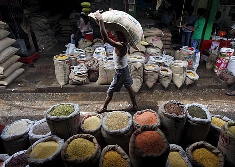 A labourer carries a sack filled with pulses at a wholesale pulses market in Kolkata. (File photo | Reuters)