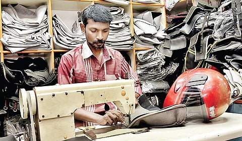 The man is stitching the padding inside the helmets  P Jawahar