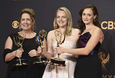 Ann Dowd, from left, winner of outstanding supporting actress in a drama series, Elisabeth Moss, winner of outstanding lead actress in a drama series, and Alexis Bledel, winner of outstanding guest actress in a drama for 'The Handmaid's Tale' pose in the 