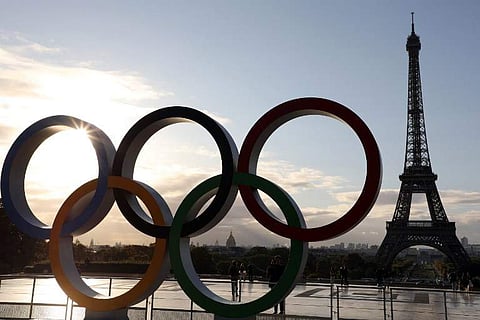People take pictures of the Olympic rings installed on the Esplanade du Trocadero near the Eiffel tower following the Paris' nomination as host for the 2024 Olympics.|AFP