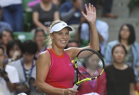 Caroline Wozniacki of Denmark celebrates after defeating Garbine Muguruza of Spain during their semi-final match of the Pan Pacific Open tennis tournament in Tokyo, Saturday. | AP