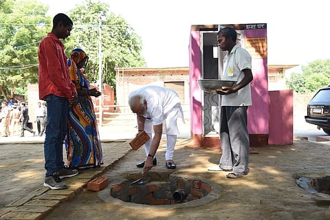 PM Narendra Modi doing shramdan for the construction of a twin pit toilet at Village Shahanshahpur, Varanasi.(Photo: Twitter via PIB India)