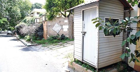 A footpath on Sadashivanagar 18th Cross has a cabin for security personnel and plants growing all over, leaving no space for pedestrians | Nagaraja gadekal