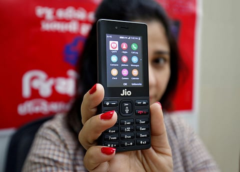 A sales person displays JioPhone as she poses for a photograph at a store of Reliance Industries' Jio telecoms unit on the outskirts of Ahmedabad on September 26. (Photo | Reuters)