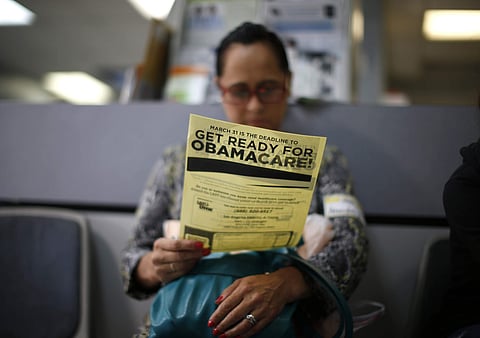 A woman reads a leaflet on Obamacare. (File | Reuters)