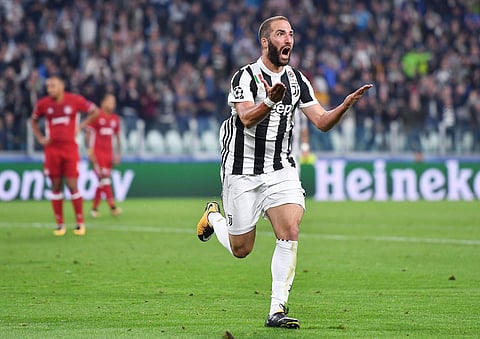 Juventus' Gonzalo Higuain celebrates after scoring during the Champions League group D soccer match between Juventus and Olympiakos, at the Allianz stadium in Turin, Italy. (AP)