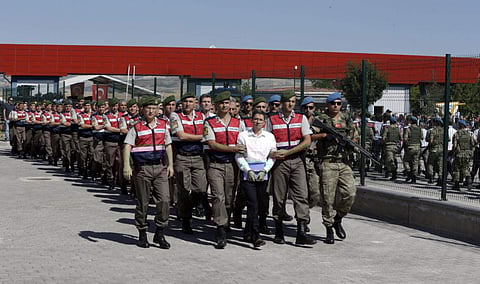Paramilitary police and members of the special forces escort unidentified suspects of last year's failed coup, outside the courthouse at the start of a trial, in Ankara, Turkey on August 1,2017. (File Photo | AP)