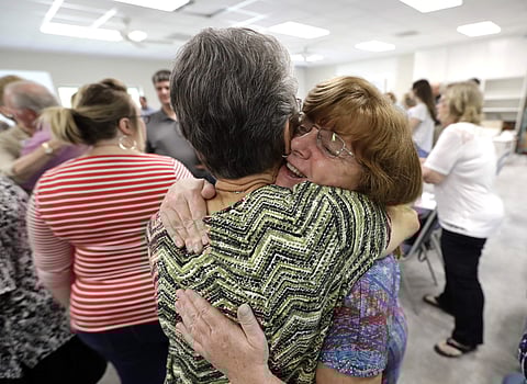 Chris Kaplan, right, hugs flood victim Betty Locklear during service at Christ United Church in the aftermath of Hurricane Harvey. | AP