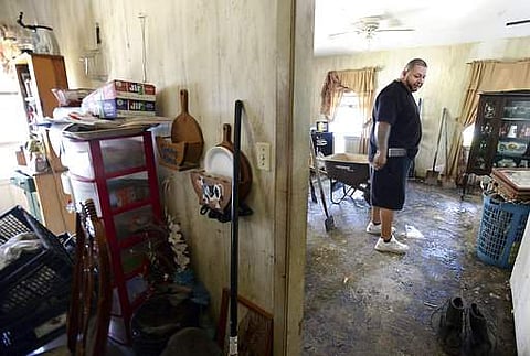 Fernando Martinez surveys the flood damaged structure, furniture and other items inside his father Santiago Martinez's home as residents throughout Port Arthur begin cleaning and salvaging their flood damaged homes in Beaumont. | AP