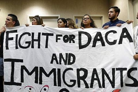 People hold up a banner during an event to protest President Donald Trump's decision to revoke the Deferred Action for Childhood Arrivals program. | AP