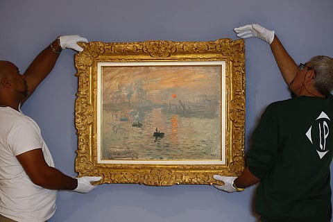 Employees remove Claude Monet's masterpiece 'Impression, Sunrise' depicting his hometown of Le Havre, that's credited with spawning the word 'Impressionism' , at Marmottan Museum, in Paris on Wednesday. (Photo | AP)
