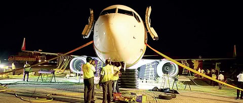 The members of DART team trying to lift the aircraft from the drain pit to take it to the maintenance hangar of Kochi airport on Tuesday night  | EXPRESS