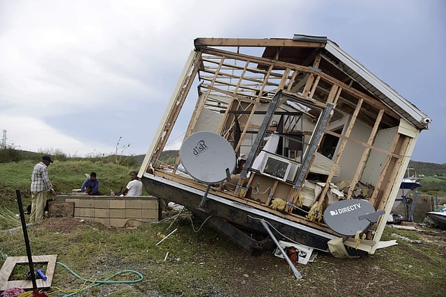 A man with his family members standing in front of whats left of his damaged property, after the passage of Hurricane Irma, in the island of Culebra, Puerto Rico. ( Photo | AP)