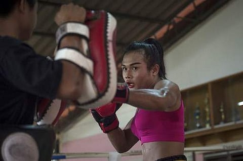 This photograph taken on December 15, 2017 shows Muay Thai boxer Nong Rose, 21, doing pad work during a training session in Thailand's central province of Chachoengsao. | AFP