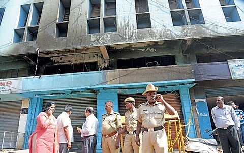 BESCOM and police officials visit the building in Kalasipalya on Tuesday where a fire at a bar killed five people on Monday | Vinod Kumar T